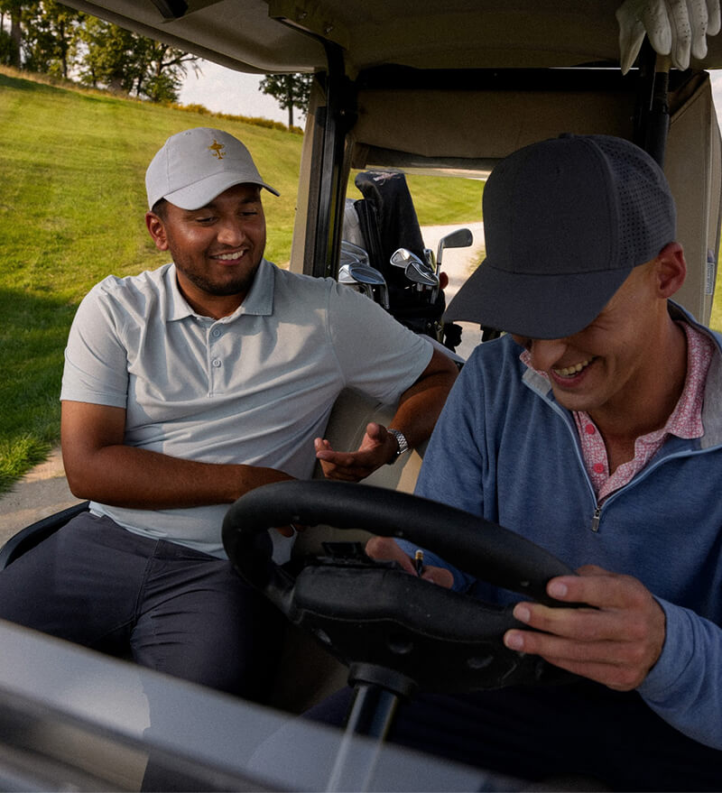 Two golfers laughing in a cart